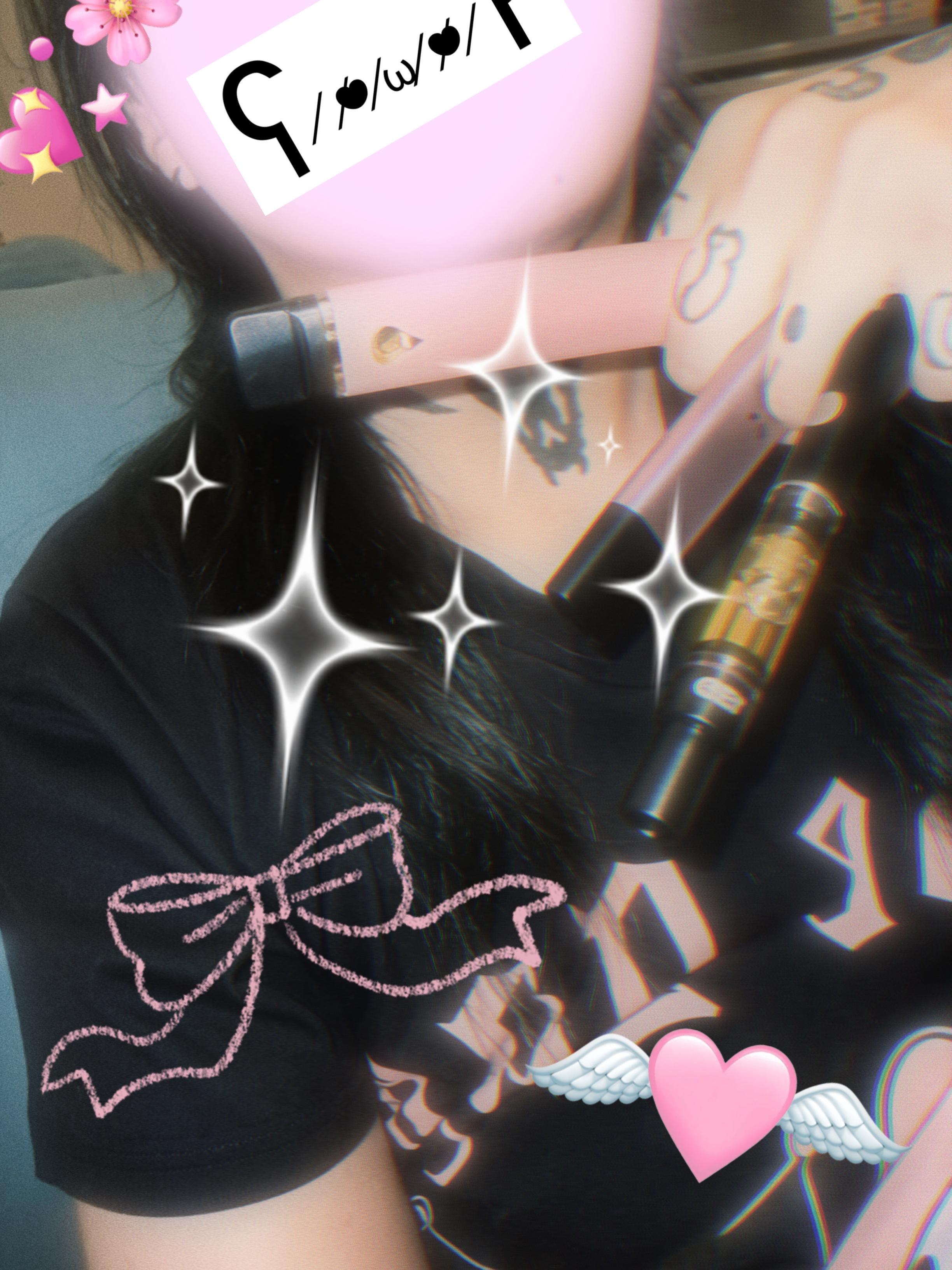 A photo of an Asian person with long black hair and their face blocked out is holding three vaporisers in between their fingers. They are holding a pink Rove Diamond Series, pink PAX ERA GO, and a black 510-thread vaporiser. There are girly stickers on the photo.